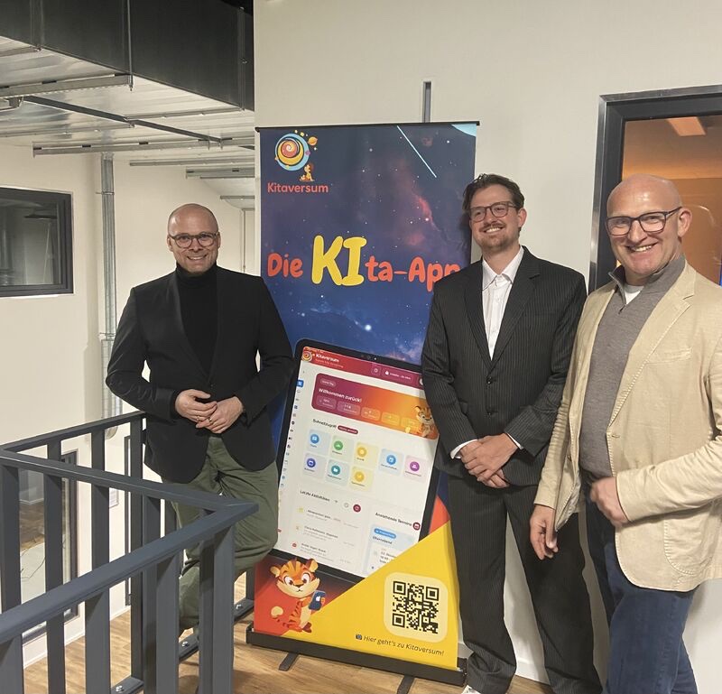 Manuel Ledutke with the Bavarian State Minister for Digital Affairs beside a Kitaversum display